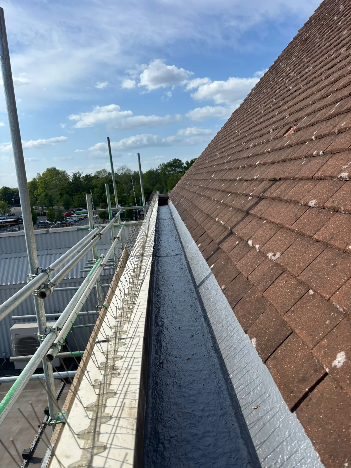 Lined box gutter beside the pitched roof at the Camberley retail building