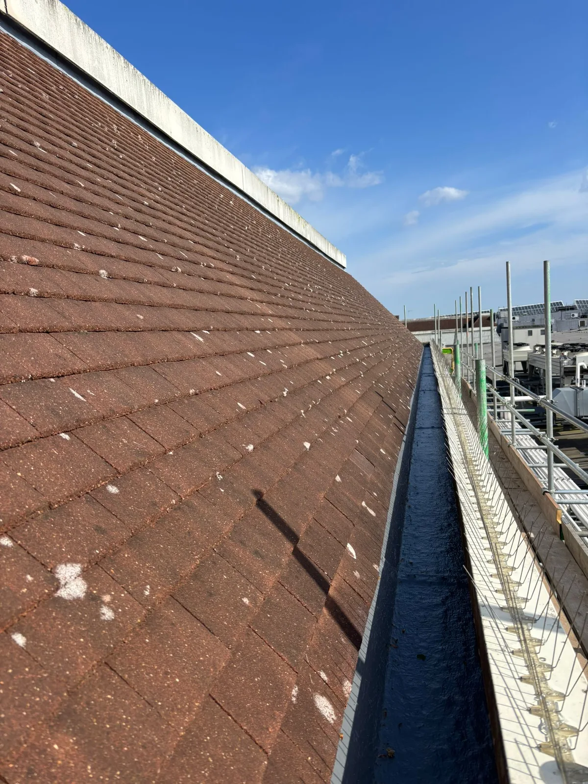 Wide view of the pitched roof and box gutter with scaffolding alongside
