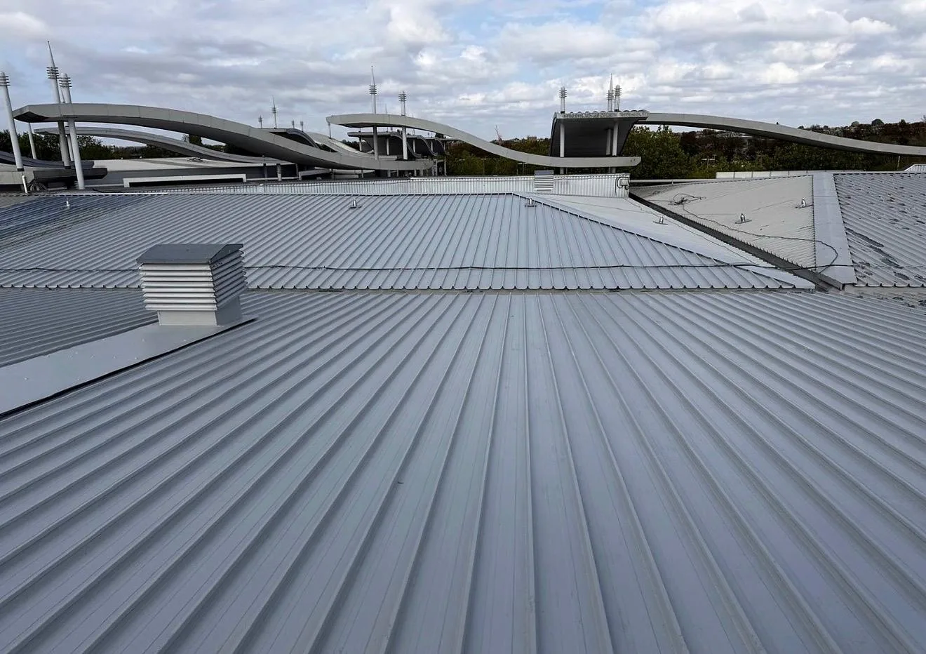Liquid-waterproofed profiled retail roof with a ventilation cowl in Greenford